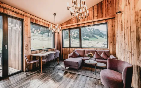 Family Suite Deluxe Cozy alpine vacation apartment living room with wood paneling and panoramic mountain view